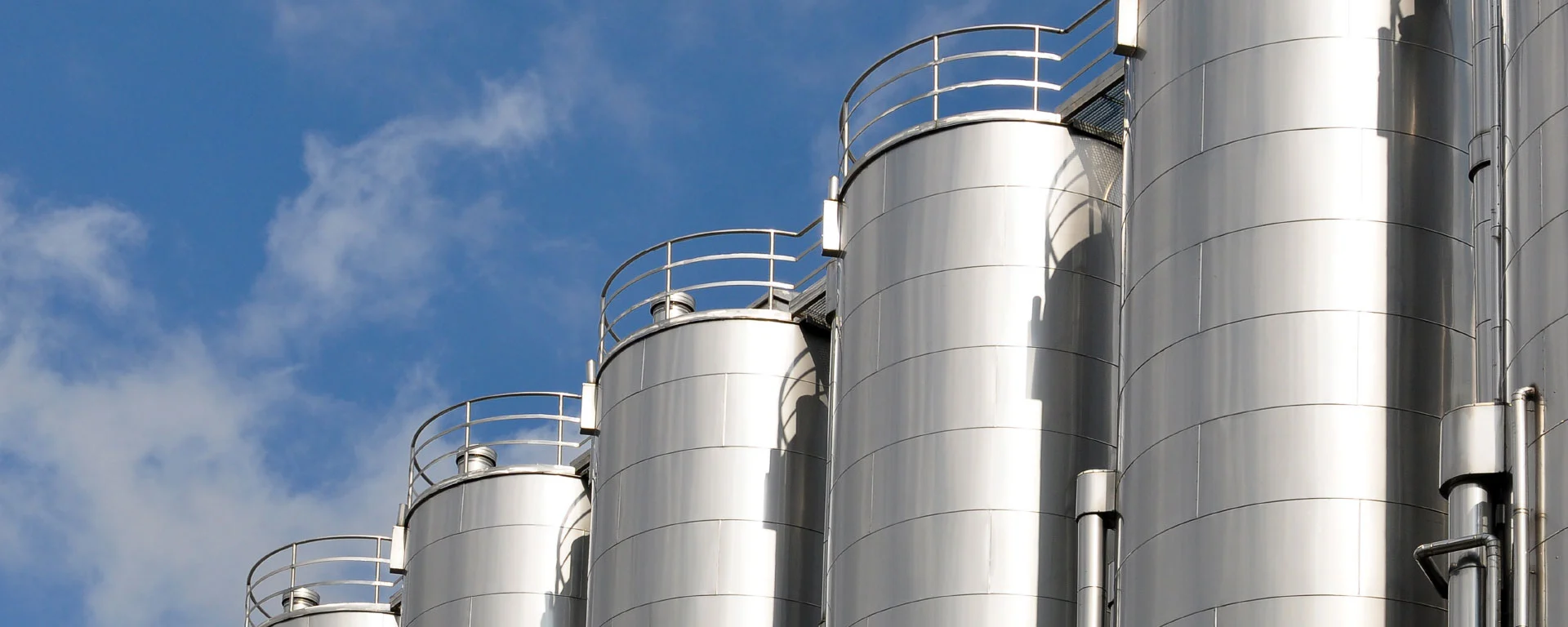 A row of staggered silos with blue sky in the background