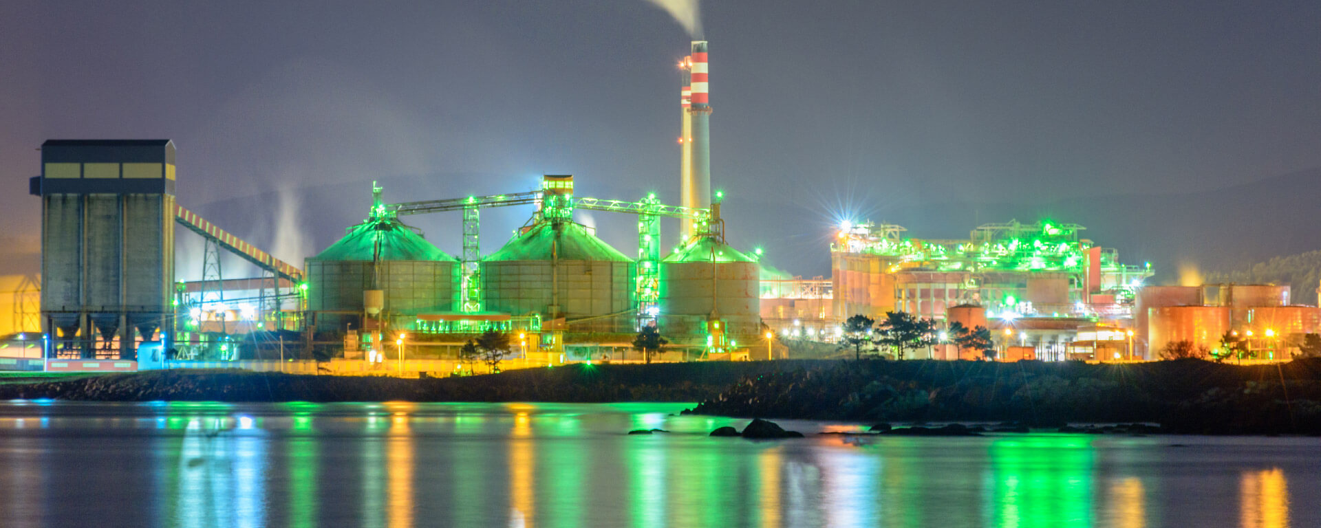 Industrial plant in front of a night sky in green illumination