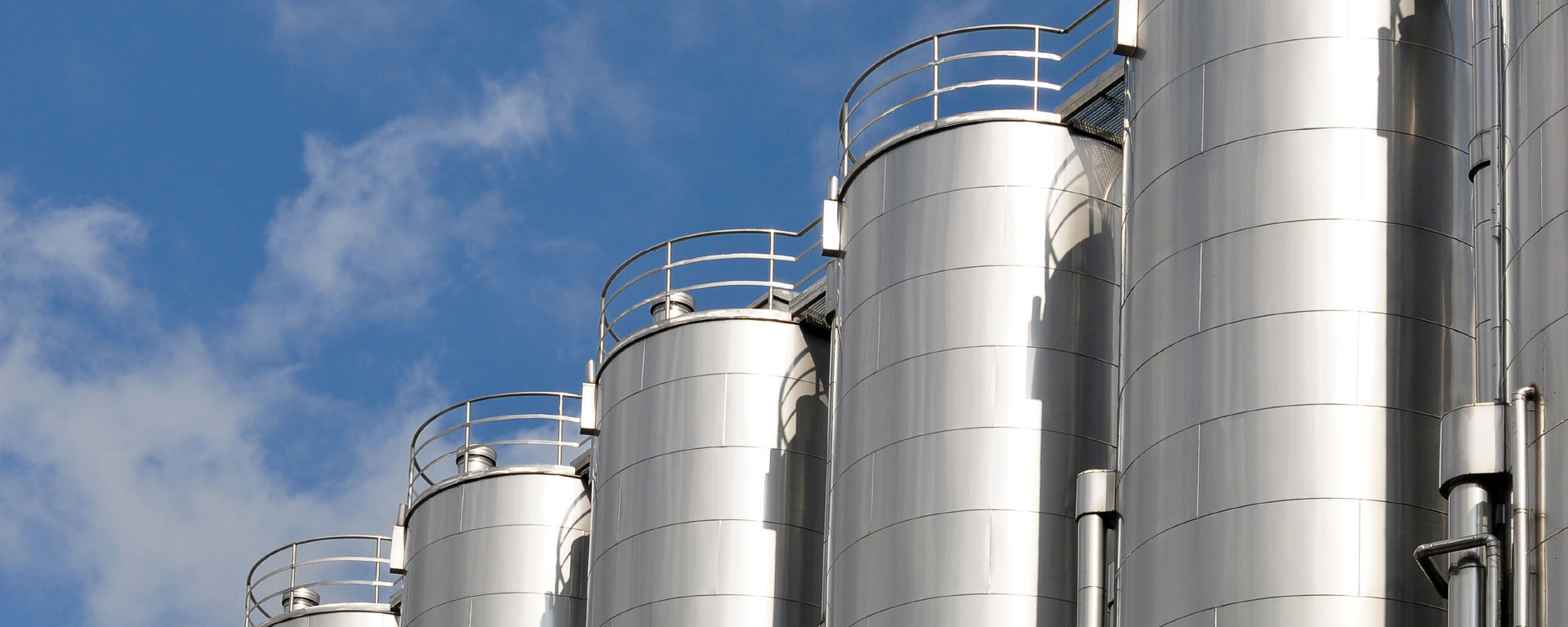 A row of staggered silos with blue sky in the background